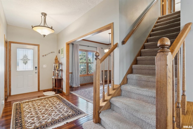 entrance foyer with stairway, wood finished floors, and baseboards