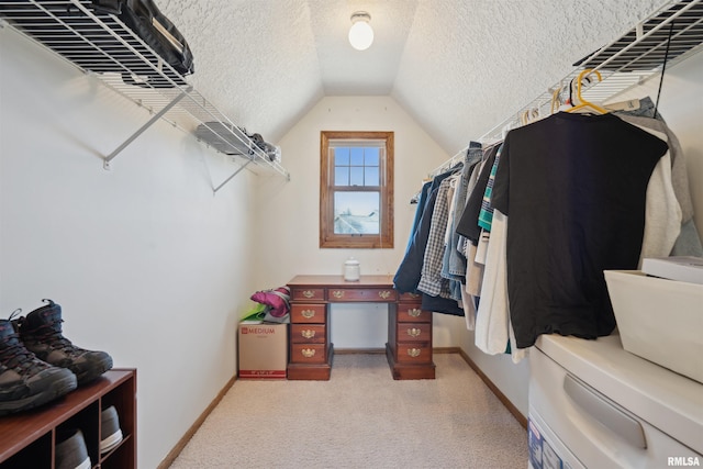 spacious closet with vaulted ceiling and light carpet