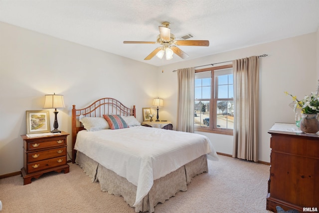 bedroom featuring visible vents, light colored carpet, a ceiling fan, and baseboards