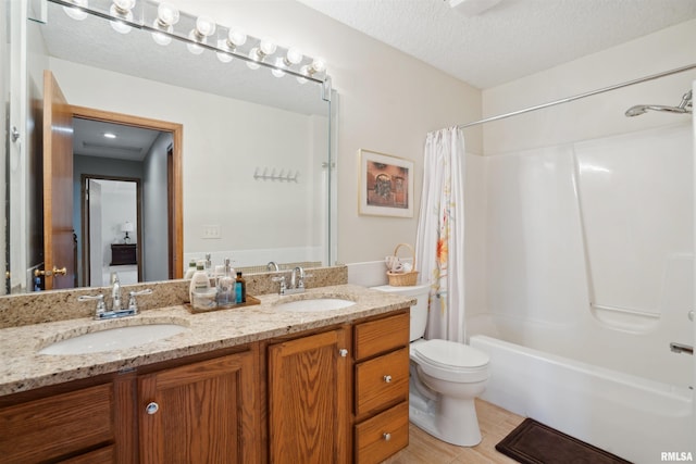 bathroom with double vanity, a textured ceiling, shower / tub combo, and a sink