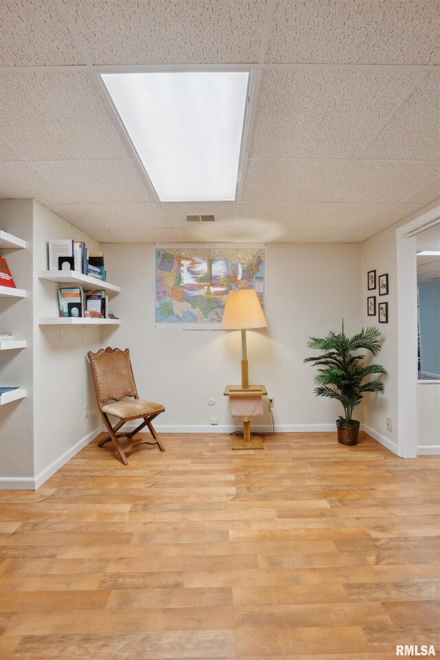 sitting room featuring a paneled ceiling, visible vents, baseboards, and wood finished floors