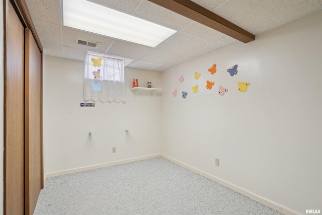 unfurnished room featuring visible vents, carpet flooring, a paneled ceiling, and baseboards