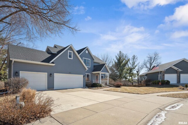 view of front of house with covered porch, roof with shingles, and concrete driveway