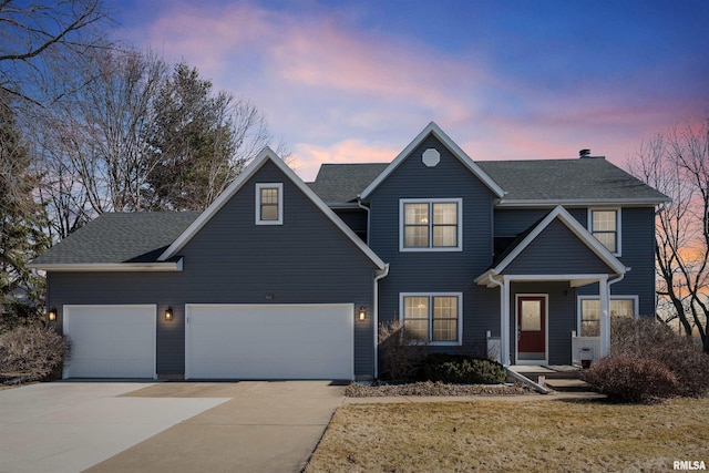 view of front of home with driveway, an attached garage, and a shingled roof