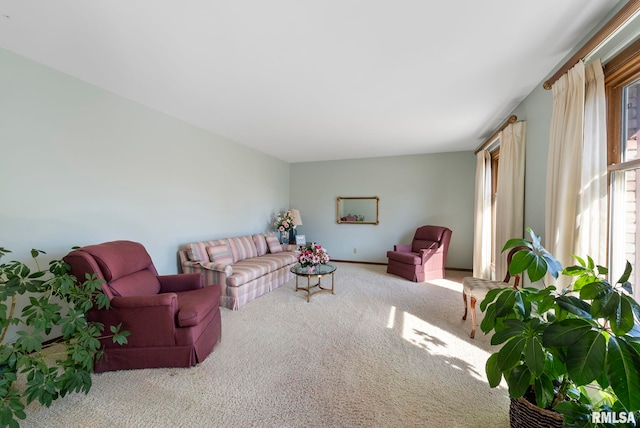 carpeted living area featuring baseboards