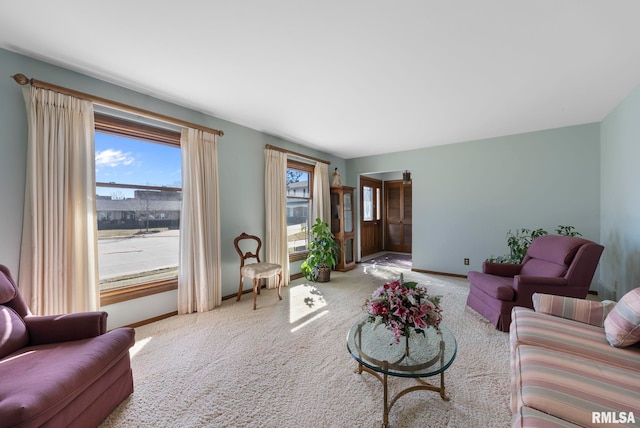 carpeted living room featuring baseboards