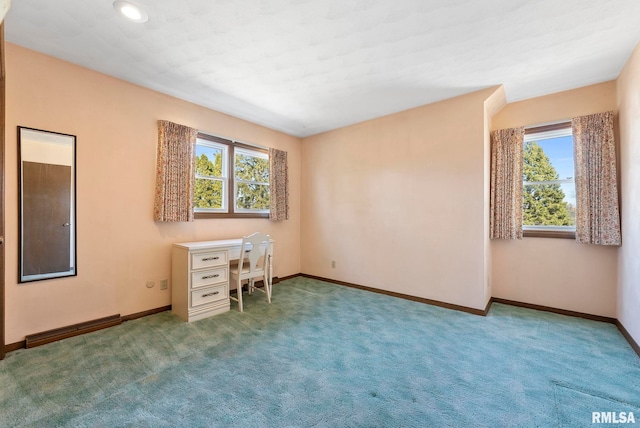 unfurnished office with baseboards, plenty of natural light, carpet, and visible vents