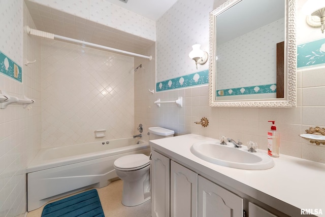 bathroom with vanity, wallpapered walls, wainscoting, tile walls, and toilet