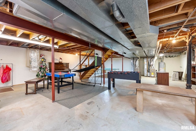 unfinished basement featuring stairway and water heater