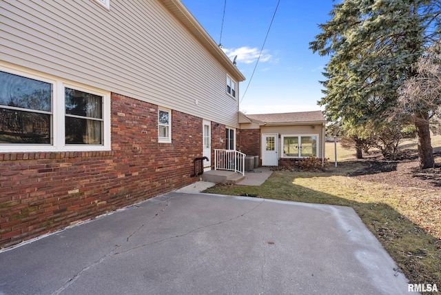 exterior space featuring brick siding and a patio area