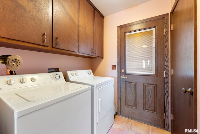 laundry room featuring light tile patterned flooring, cabinet space, and washer and clothes dryer