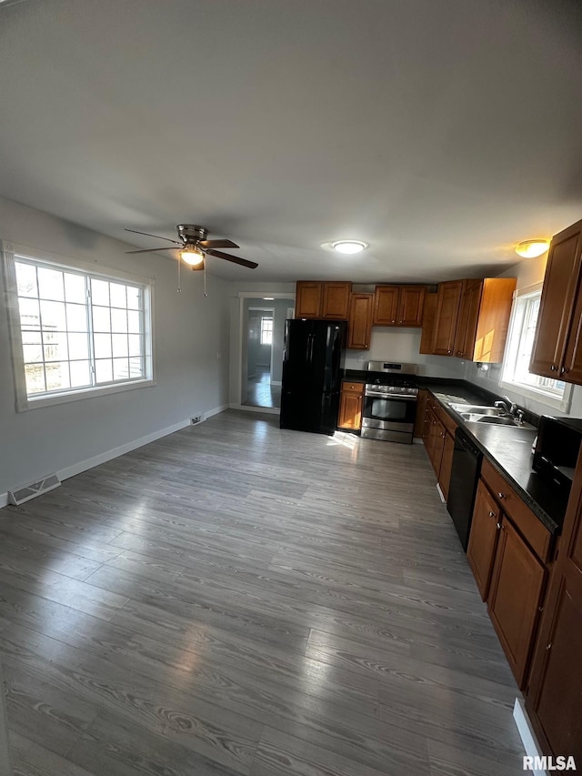 kitchen featuring visible vents, dark countertops, black appliances, and dark wood-style floors