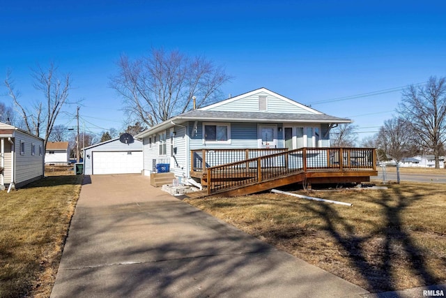 view of front of home with a detached garage, an outdoor structure, a front lawn, and a shingled roof