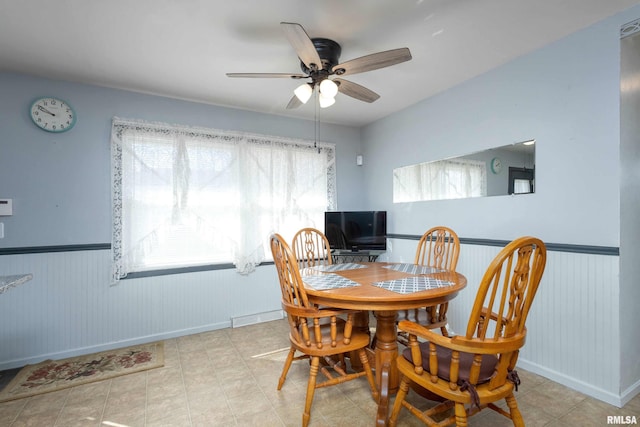 dining space featuring a wainscoted wall, a wealth of natural light, and ceiling fan