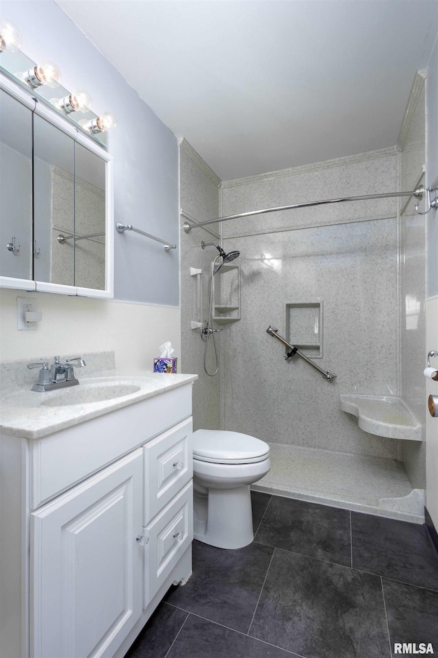 bathroom featuring tile patterned floors, toilet, walk in shower, and vanity