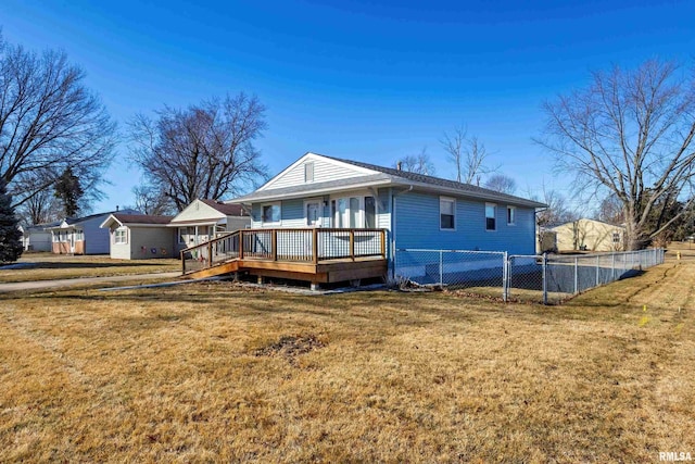 back of house with a wooden deck, a yard, and fence