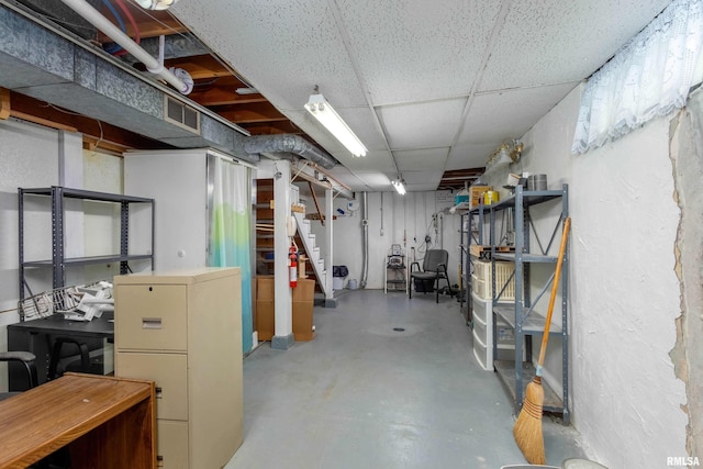 unfinished below grade area with stairs and a paneled ceiling