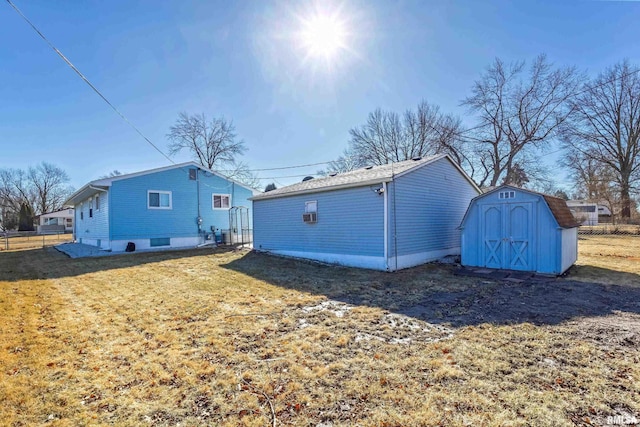 exterior space featuring an outbuilding, a storage unit, fence, and a lawn