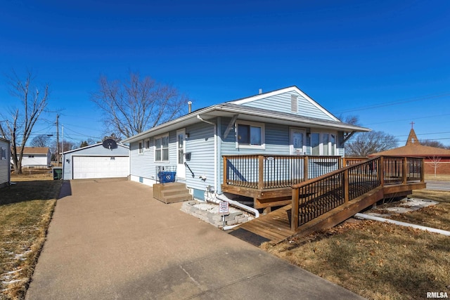 view of front of home featuring a wooden deck, a detached garage, and an outbuilding