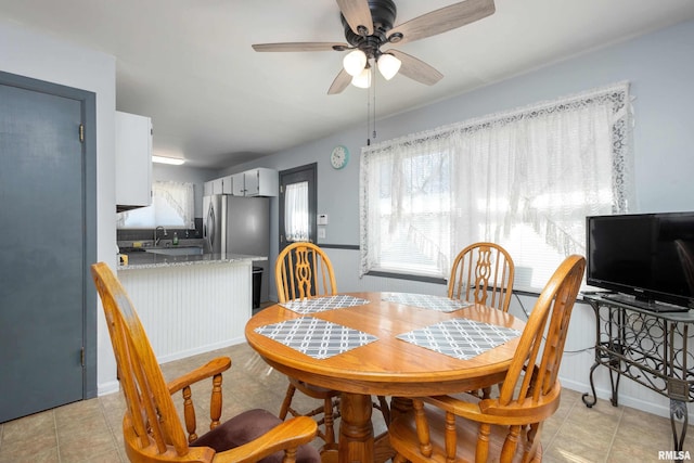 dining room featuring light tile patterned floors, baseboards, and ceiling fan