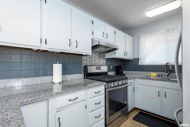 kitchen with a sink, decorative backsplash, stainless steel appliances, under cabinet range hood, and white cabinetry