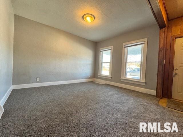 carpeted spare room with beamed ceiling and baseboards