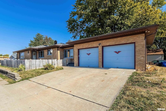 ranch-style house featuring brick siding, driveway, an attached garage, and fence