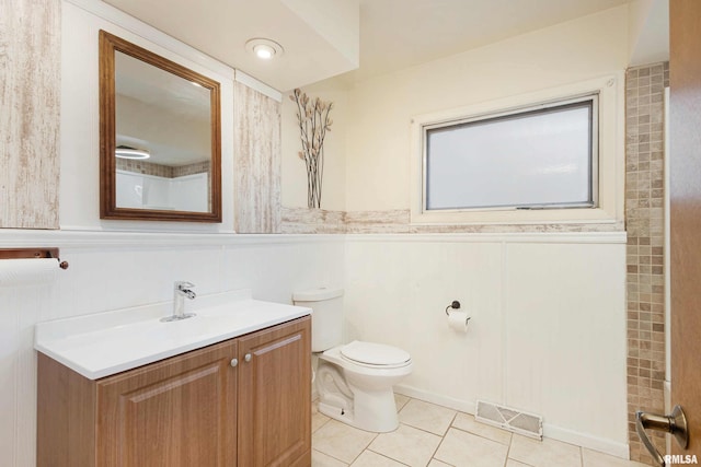 bathroom featuring visible vents, a wainscoted wall, toilet, tile patterned floors, and vanity