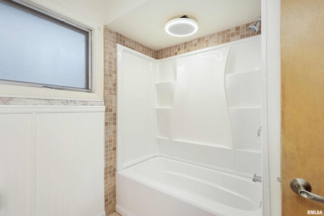 bathroom with wainscoting and shower / bathtub combination