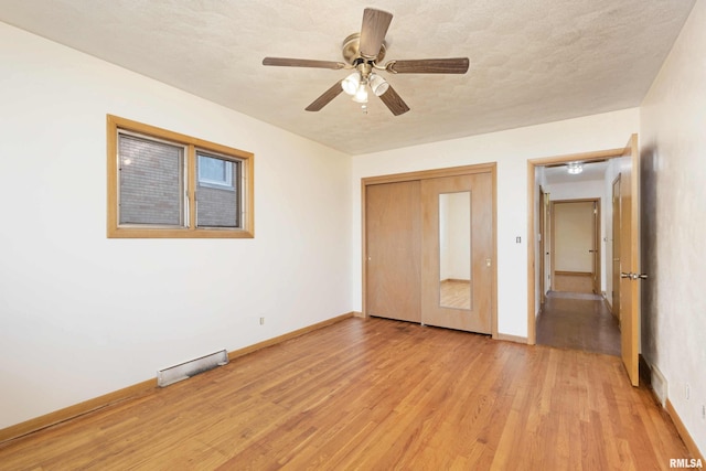 unfurnished bedroom with a closet, baseboards, visible vents, and light wood finished floors