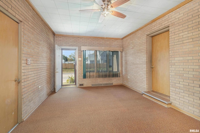 unfurnished room with a ceiling fan, brick wall, and carpet flooring