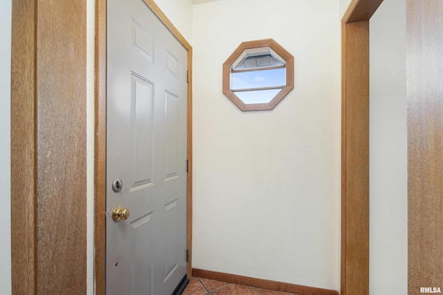 corridor featuring light tile patterned flooring and baseboards