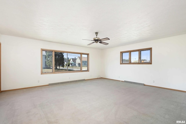 carpeted spare room with baseboard heating, baseboards, and visible vents