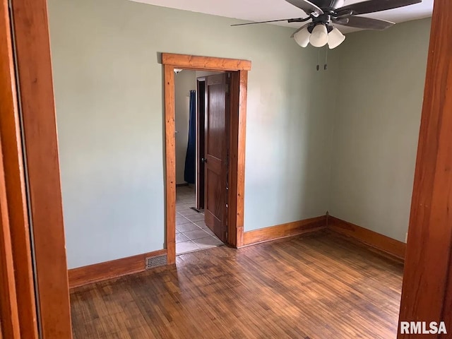 spare room with ceiling fan, baseboards, and wood finished floors