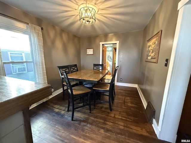 dining room with an inviting chandelier, wood finished floors, and baseboards