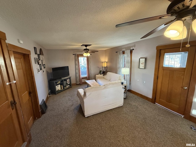 living area featuring a wealth of natural light, a textured ceiling, a ceiling fan, and carpet floors