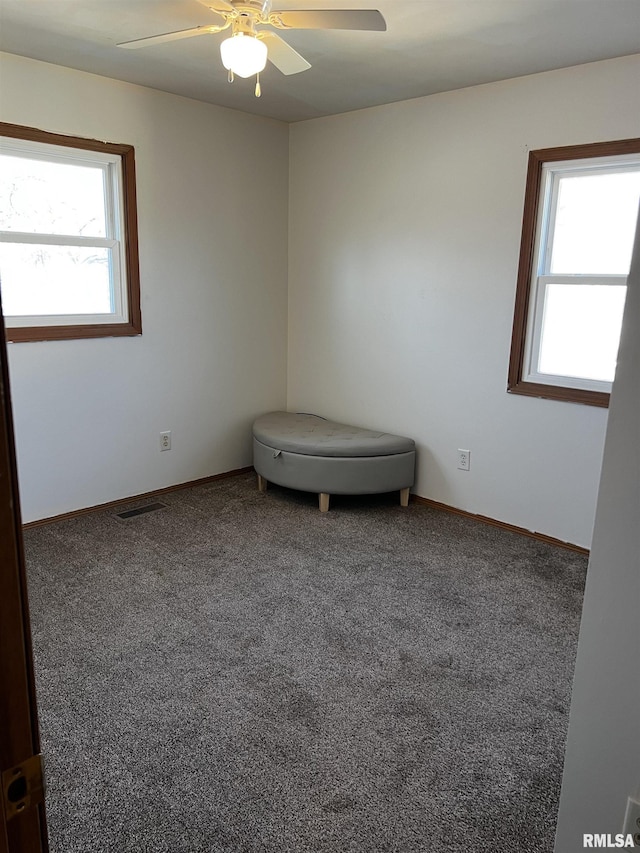 unfurnished room with carpet flooring, visible vents, baseboards, and ceiling fan