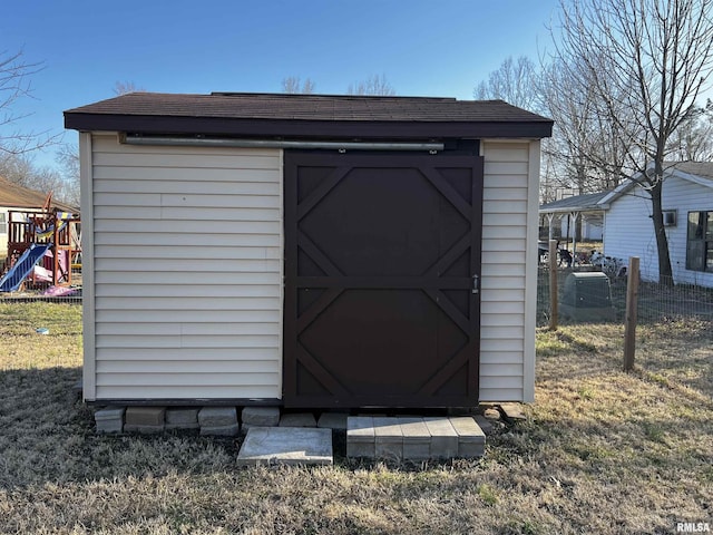 view of shed featuring a playground and fence