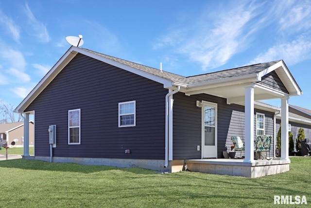 back of property with a lawn and covered porch