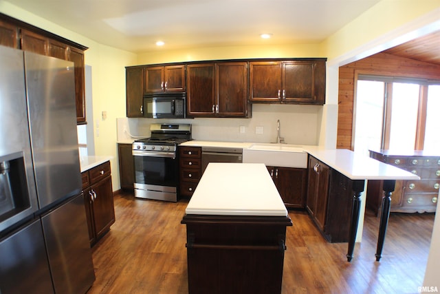 kitchen featuring a sink, a peninsula, light countertops, and stainless steel appliances