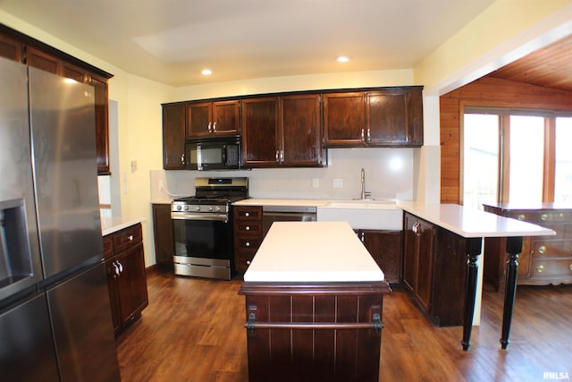 kitchen with a peninsula, light countertops, appliances with stainless steel finishes, and a sink