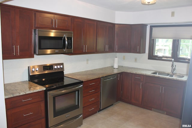 kitchen with tasteful backsplash, visible vents, light stone counters, stainless steel appliances, and a sink