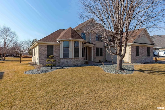 view of front of home with stone siding, a front lawn, and roof with shingles