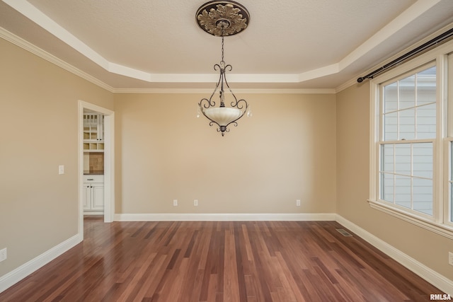 empty room with visible vents, a raised ceiling, a textured ceiling, dark wood-style floors, and baseboards