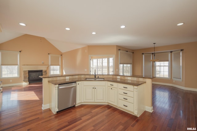 kitchen with a sink, open floor plan, dishwasher, lofted ceiling, and dark wood-style flooring