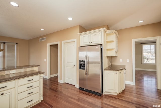 kitchen featuring dark wood-type flooring, recessed lighting, visible vents, and stainless steel fridge