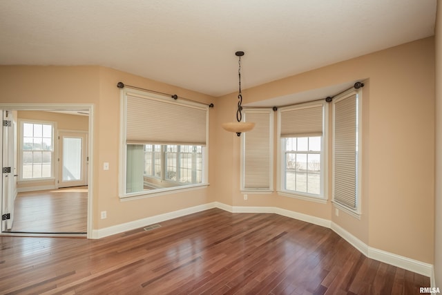 interior space featuring a wealth of natural light, baseboards, and wood finished floors