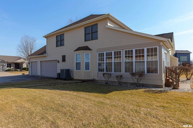 exterior space featuring a front yard, central AC, and driveway