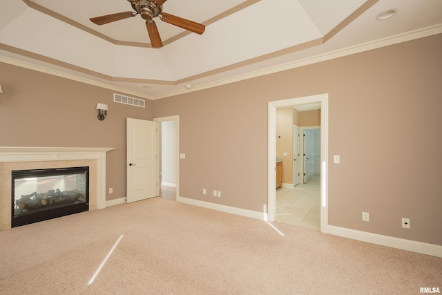 unfurnished living room with visible vents, a raised ceiling, carpet, and ornamental molding