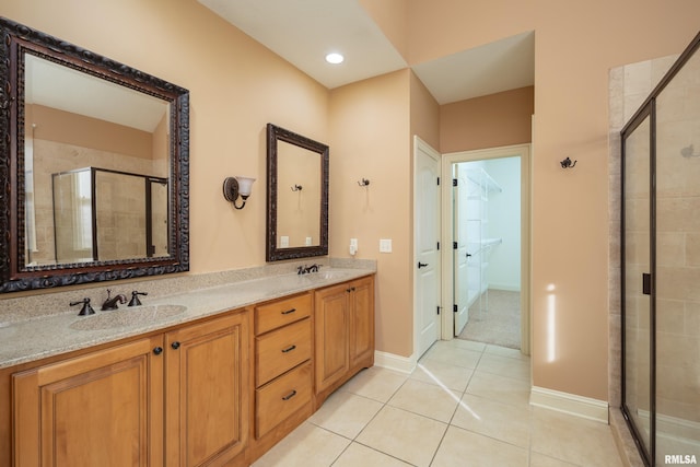 full bathroom with a sink, double vanity, a shower stall, and tile patterned flooring